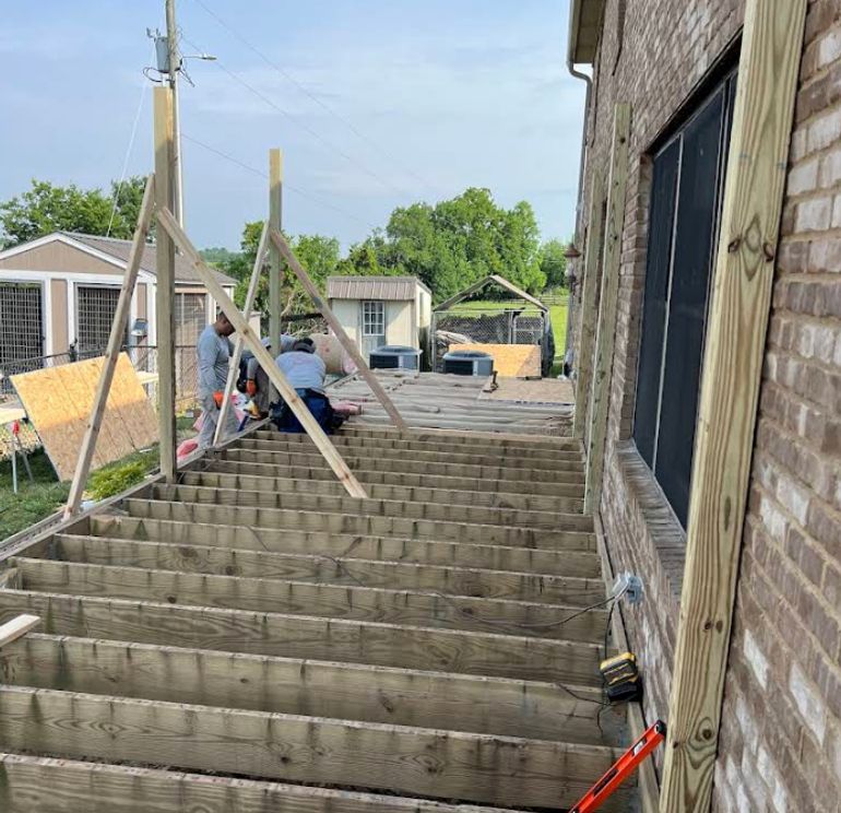New wooden staircase under construction on a brick home