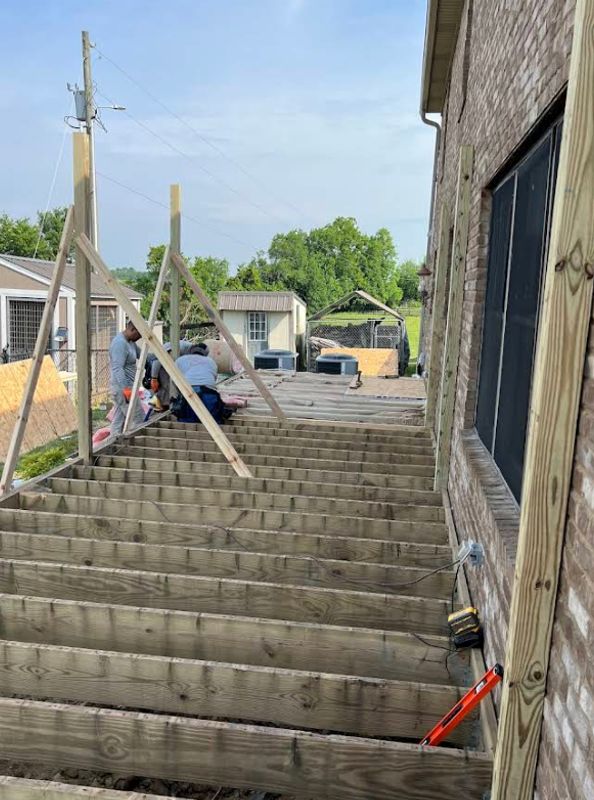 Newly built wooden staircase on the side of a brick home