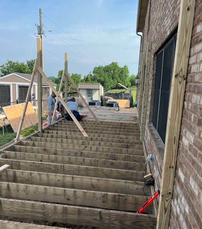 New wooden staircase under construction on a brick home